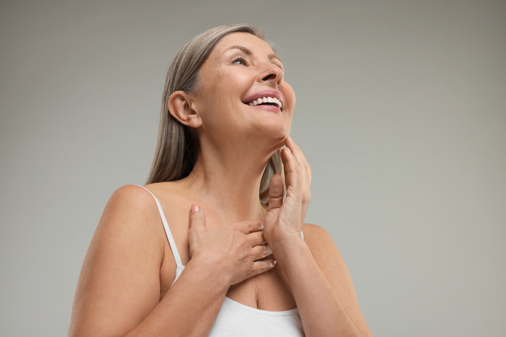 Mature woman smiling and showing off her younger looking neck after neck lift.