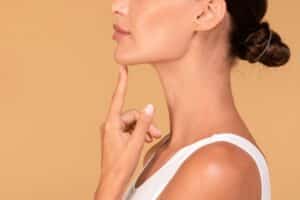 Side profile of woman's beautiful chin and neckline after chin surgery
